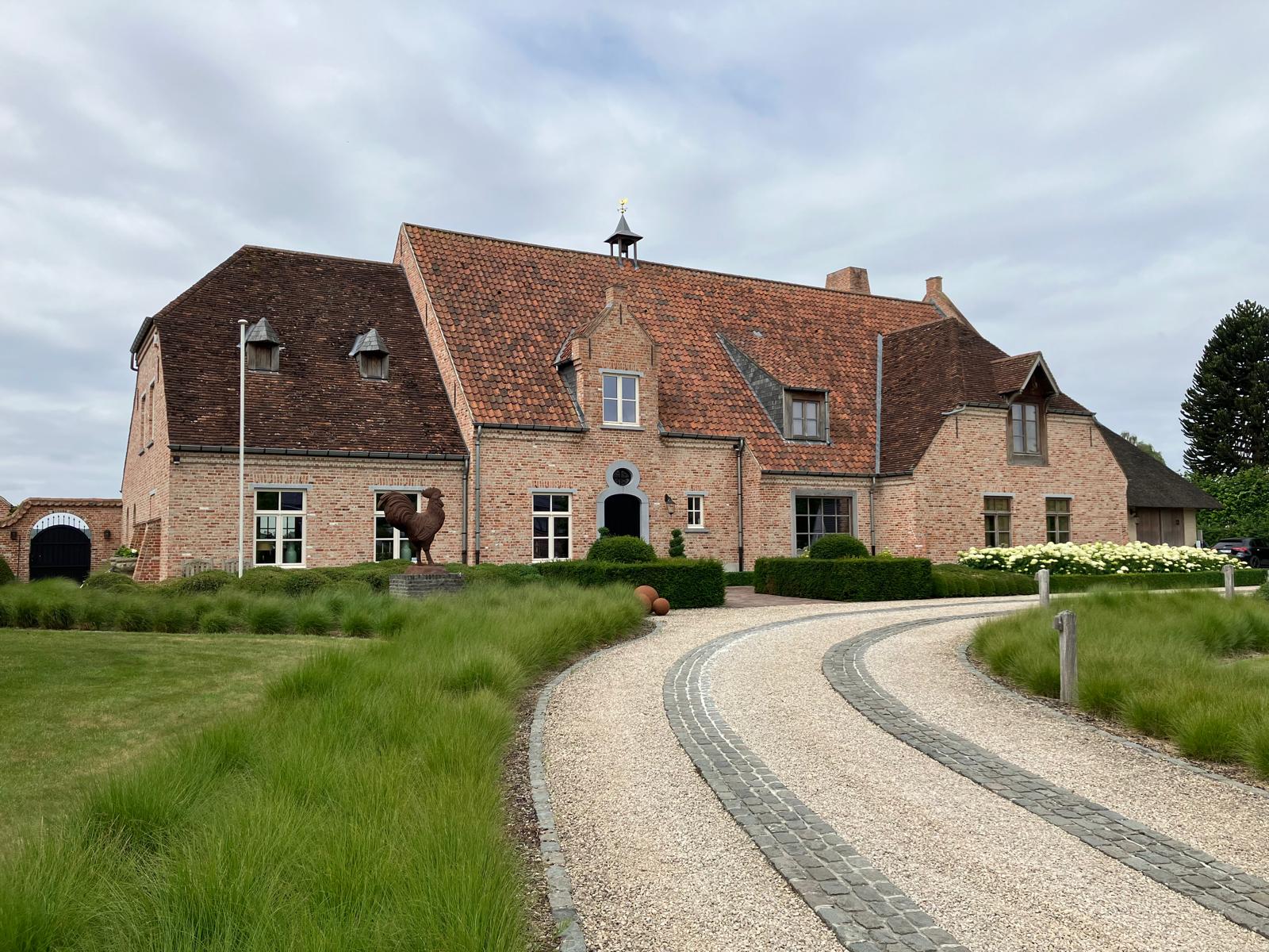 B&B De Brakelhoen in Nederbrakel, gebouw in rode baksteen met dakkapellen en een torentje op de nok