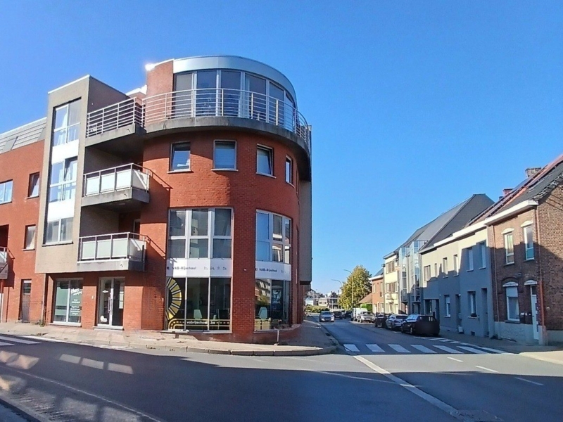 Ronde hoekgevel in rode baksteen met terrassen met glazen balustrades, in Zottegem